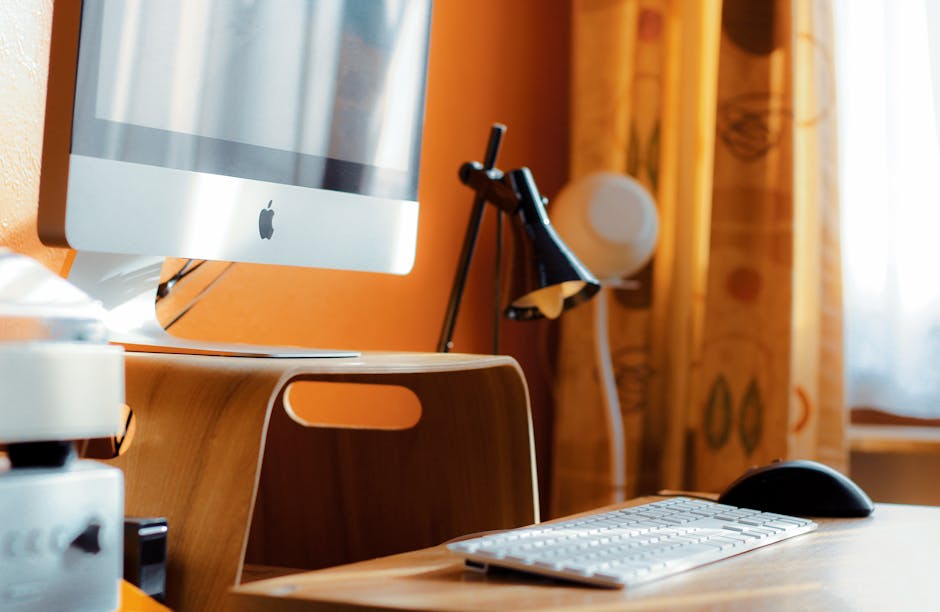 Contemporary home office setup with a computer and desk lamp on a wooden table.