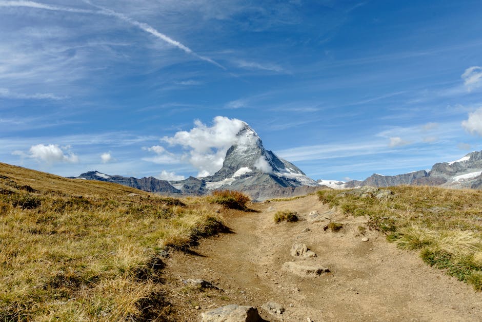 Iconic Matterhorn mountain in Switzerland with a rocky trail under a clear blue sky.