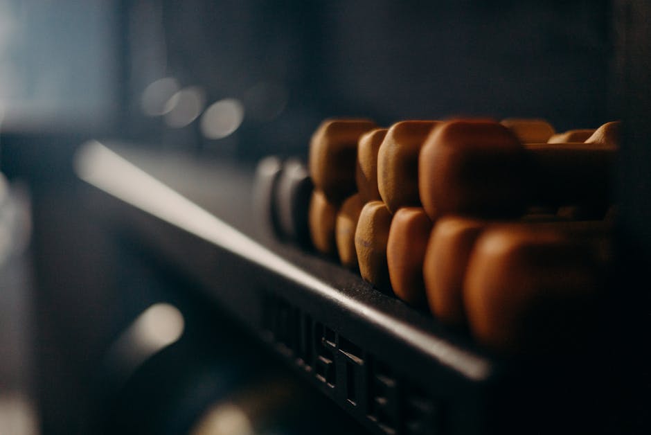 A rack of dumbbells in a dimly lit gym, highlighting fitness equipment.